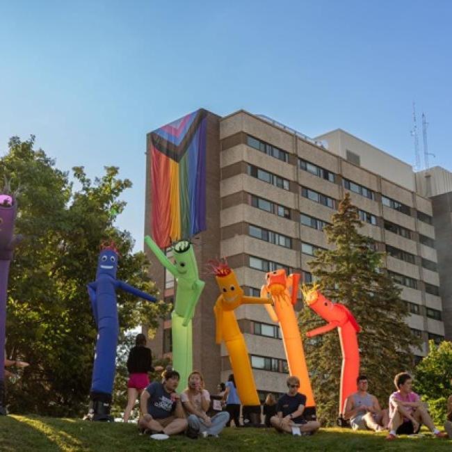 Rainbow inflatable people at Cook Out event in housing 